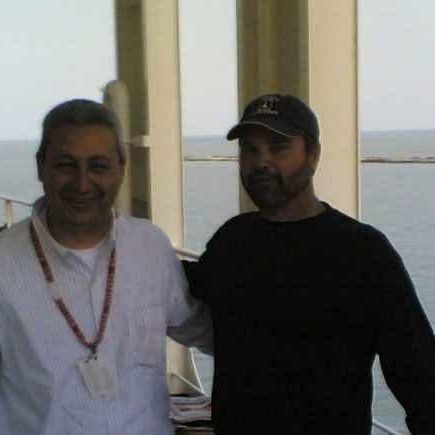 Billy Brown with a ship's officer on deck, sea behind them