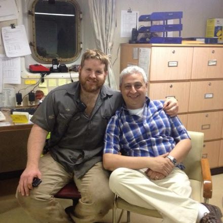 Billy Brown seated with an officer in the ship's office