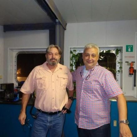 Billy Brown with a ship's master on the bridge at night
