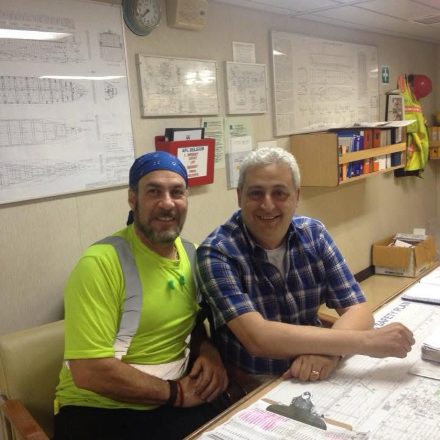 Billy Brown with an engineer at a desk on board