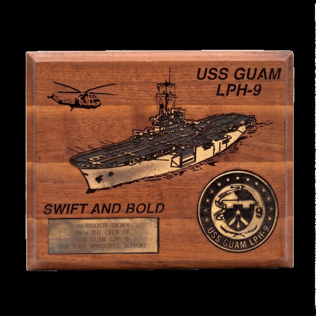 Wooden plaque of USS Guam, LPH-9, engraved To Charlie Brown from the crew, for your wonderful support
