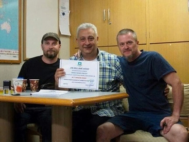 Charly Brown staff with ship officers holding a commendation