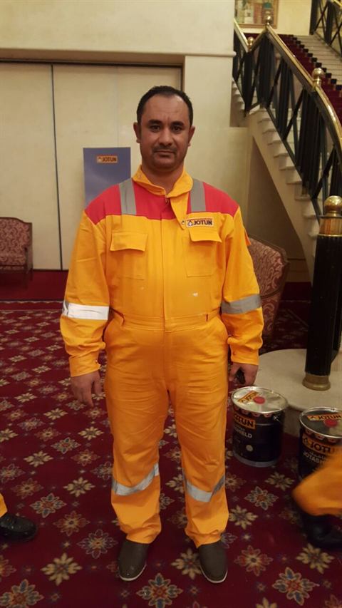 Man wearing a yellow and red Jotun coverall with reflective tape