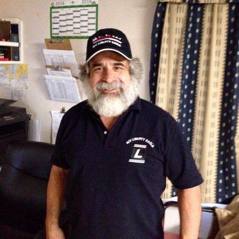 Ship's officer wearing an embroidered M/V Liberty Eagle polo shirt and cap